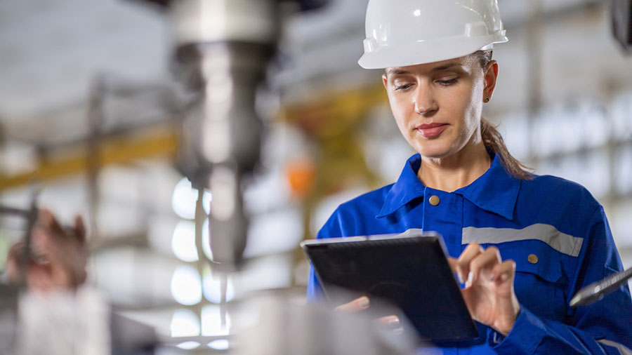 Worker performing a digital inspection for safety using a tablet at an industrial facility